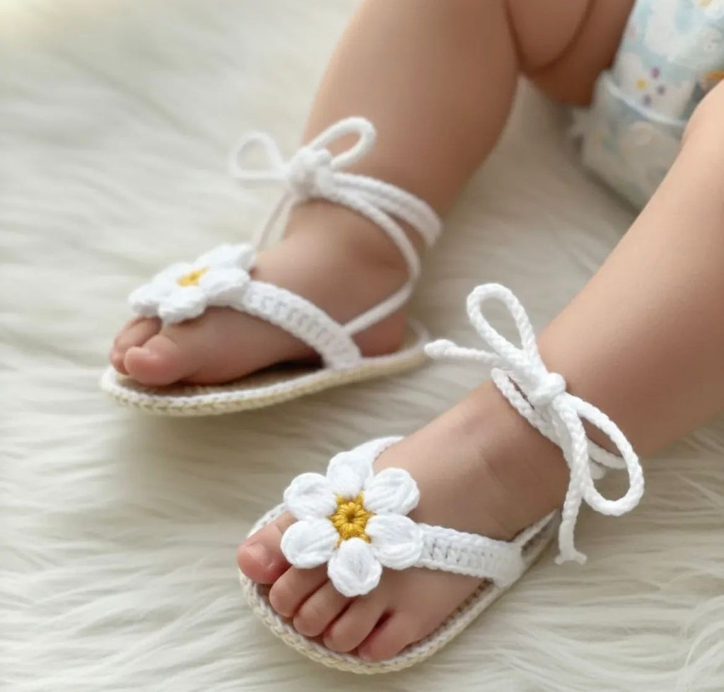 Authentic Kashmiri handmade crochet green baby booties with white rose flowers and pearl button detail held in hand Pakistan