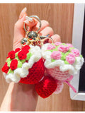 Miniature handmade crochet flower bouquet keychain in red and pink colors with green leaves, aesthetic bag accessory.